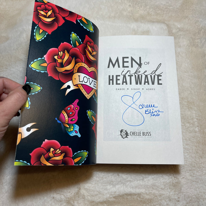 Men of Inked Heatwave Volume 3 Paperback book opened to the title page displaying a Chelle Bliss autograph.