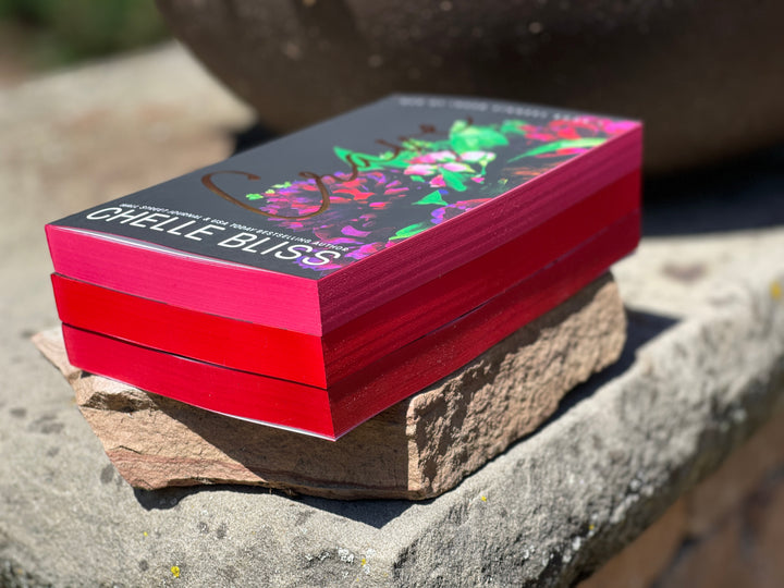 Stack of books with a colorful cover on a stone surface